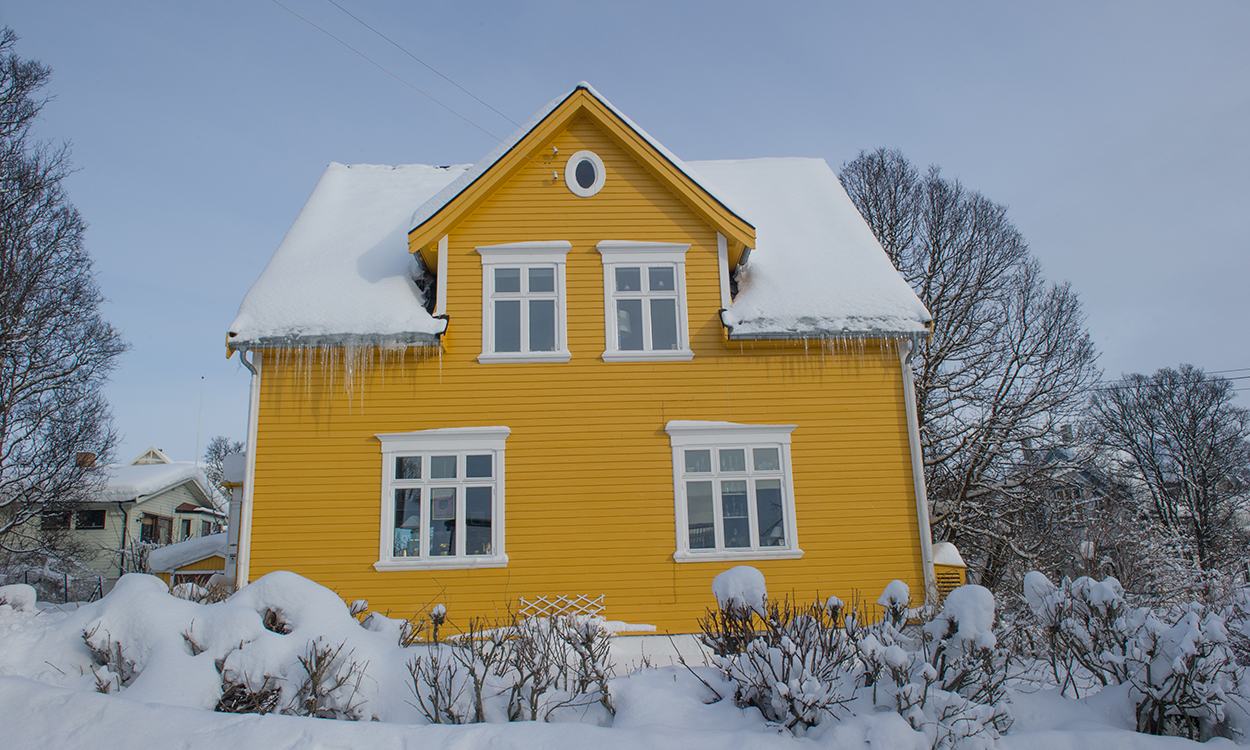 bilde av snødekt gult norsk hus