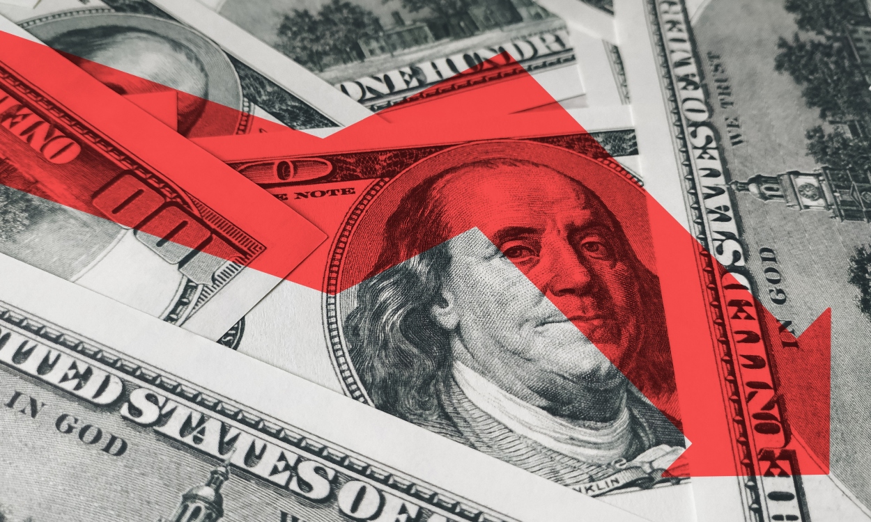 The light red arrow icon on a background of money. The concept of changing course of US dollar on the market. Devaluation, collapse, stagnation of the economy.