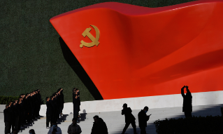 Chinese Communist Party members pose for photos with a sculpture of the party flag outside the Museum of the Communist Party of China in Beijing, China, Friday, Nov. 12, 2021. China says it is a nation "ruled by law," but the Communist Party ultimately holds sway and there are large gray areas of enforcement. Control over the press and social media allows authorities to keep word of disappearances quiet and to stonewall critics, although such news often gradually surfaces through underground and foreign sources. (AP Photo/Ng Han Guan)