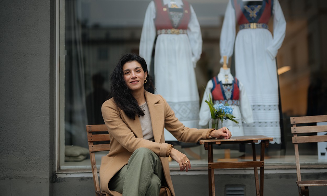 Behnaz Ganji sitter utenfor en forretning som selger bunader i Bergen.