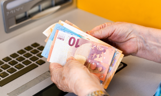 Levi holder plakat med teksten "Betal alltid i lokal valuta"