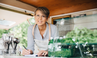 Portrait of mature owner taking order while standing in food truck