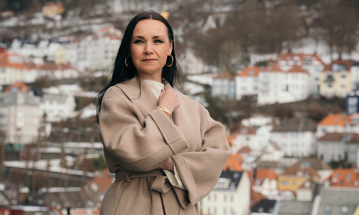 Renate Sørestrand-Hansen står på taket til Toralmenning 2 i Bergen med villaer i bakgrunnen.