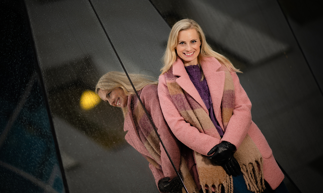 Silje Sandmæl står ved et speil utenfor DNBs hovedkontor. 
