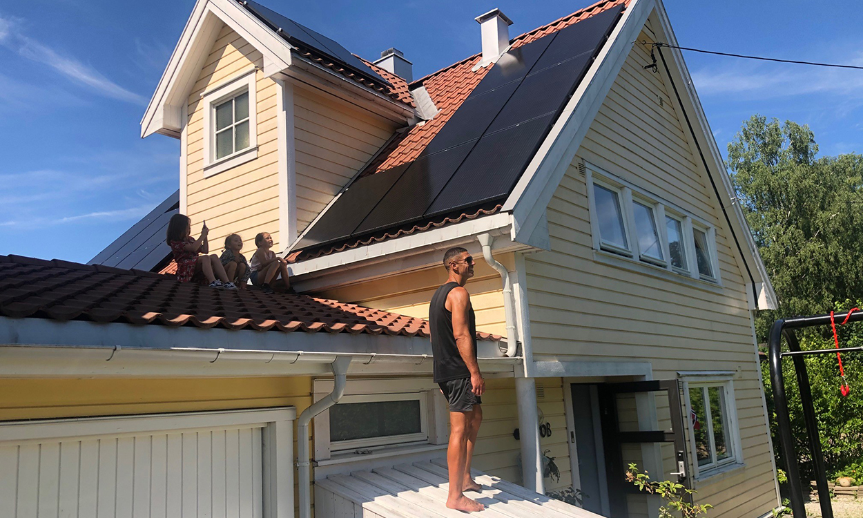 Yngvar Andersen og de tre barna han på garasjetaket for å se på selcellepanelene på hustaket.