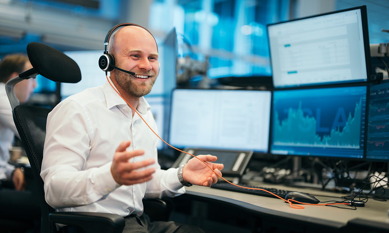 Trym Smedsrud prater med kunder i meglerhallallen til DNB Markets.