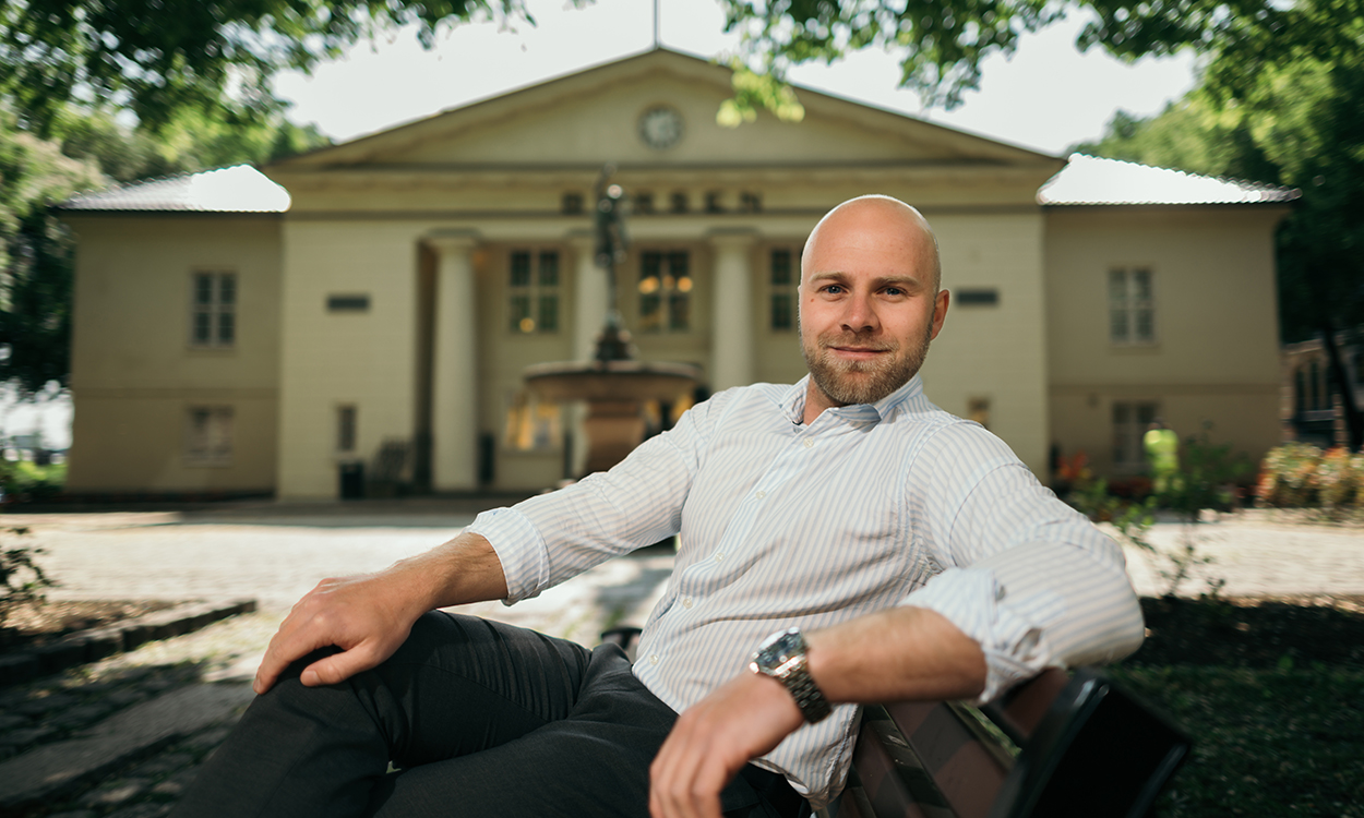 Trym Smedsrud sitter på en benk utenfor Oslo Børs.