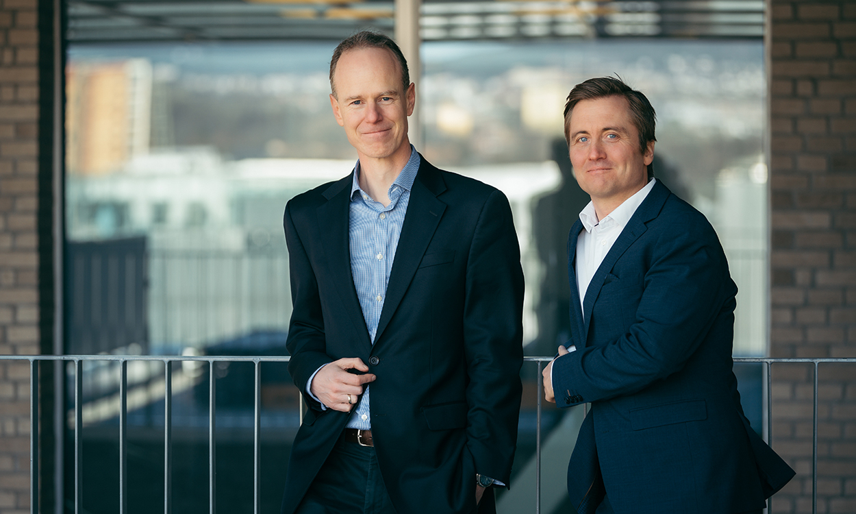 Paul Harper og Marius Brun Haugen står på en balkong i nærheten av meglerhallen til DNB Markets i Bjørvika. 