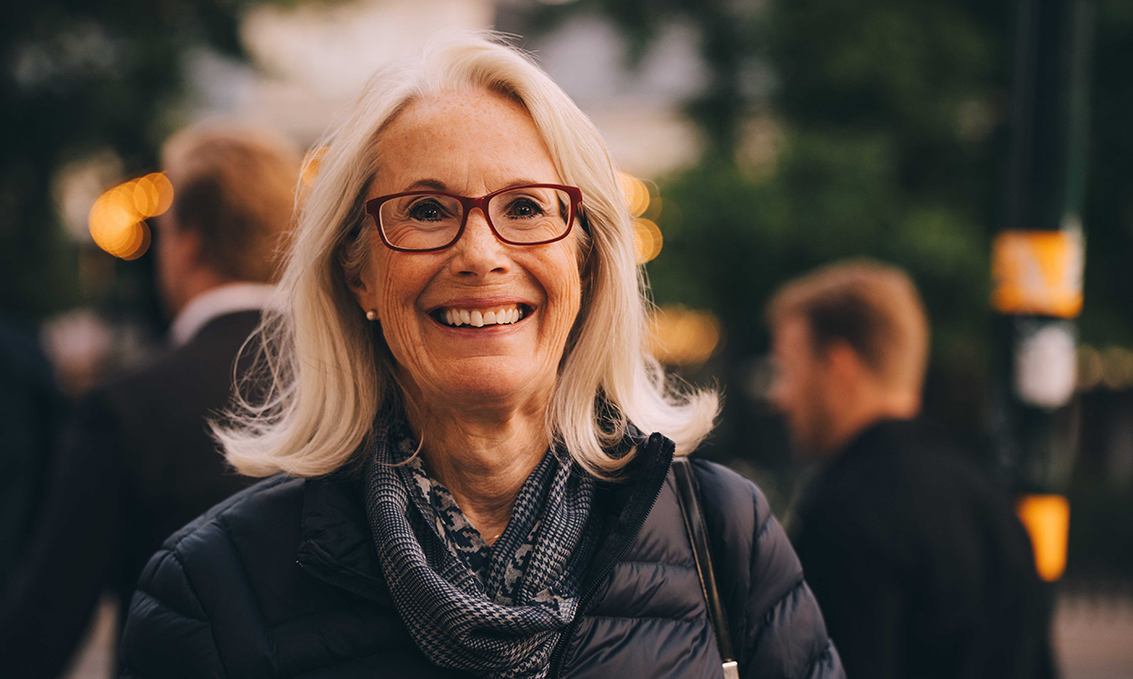 Portrait of smiling senior woman standing in city