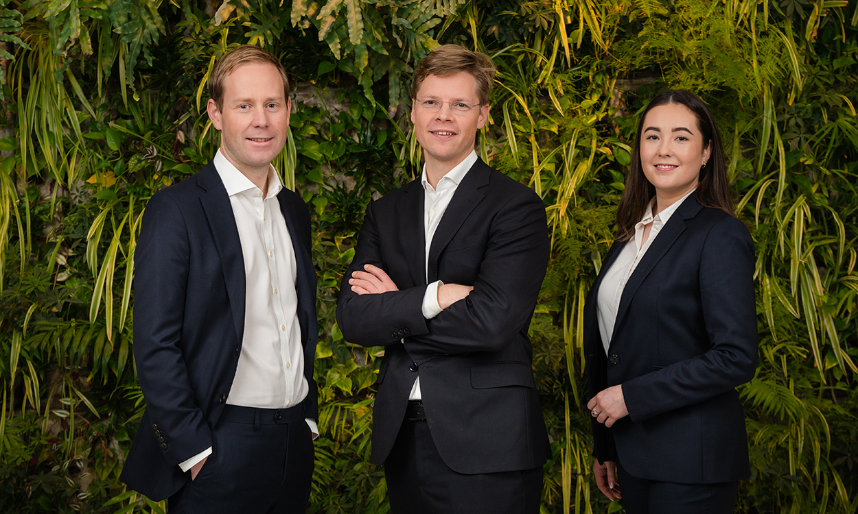 Stian Melhus Ueland, Christian Bergholt Rom og Laura Natumi McTavish står foran veggen med grønne planter hos DNB i Bjørvika. 