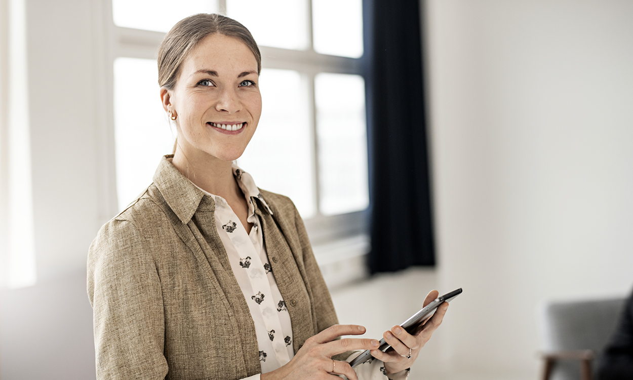 Businesswoman with cell phone looking at camera