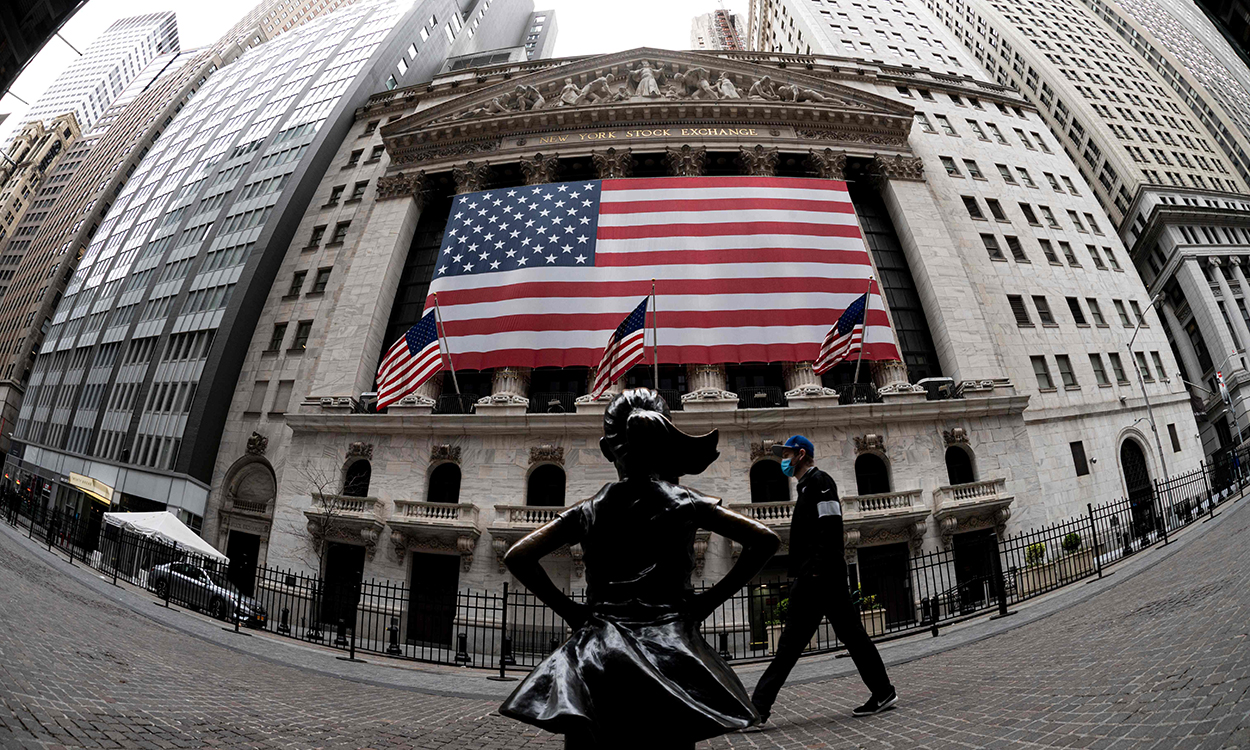 In this file photo the fearless girl statue and the New York Stock Exchange (NYSE) are pictured on April 20, 2020 at Wall Street in New York City. - After two down sessions, Wall Street stocks opened higher April 22, 2020 following strong earnings from Netflix and some other companies, while oil prices continued to gyrate. About five minutes into trading, the Dow Jones Industrial Average stood at 23,478.69, up 2.0 percent.The broad-based S&P 500 also gained 2.0 percent to 2,790.25, while the tech-rich Nasdaq Composite index advanced 2.1 percent to 8,434.04. (Photo by Johannes EISELE / AFP)