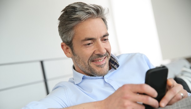 Glad mann sjekker mobilbanken 