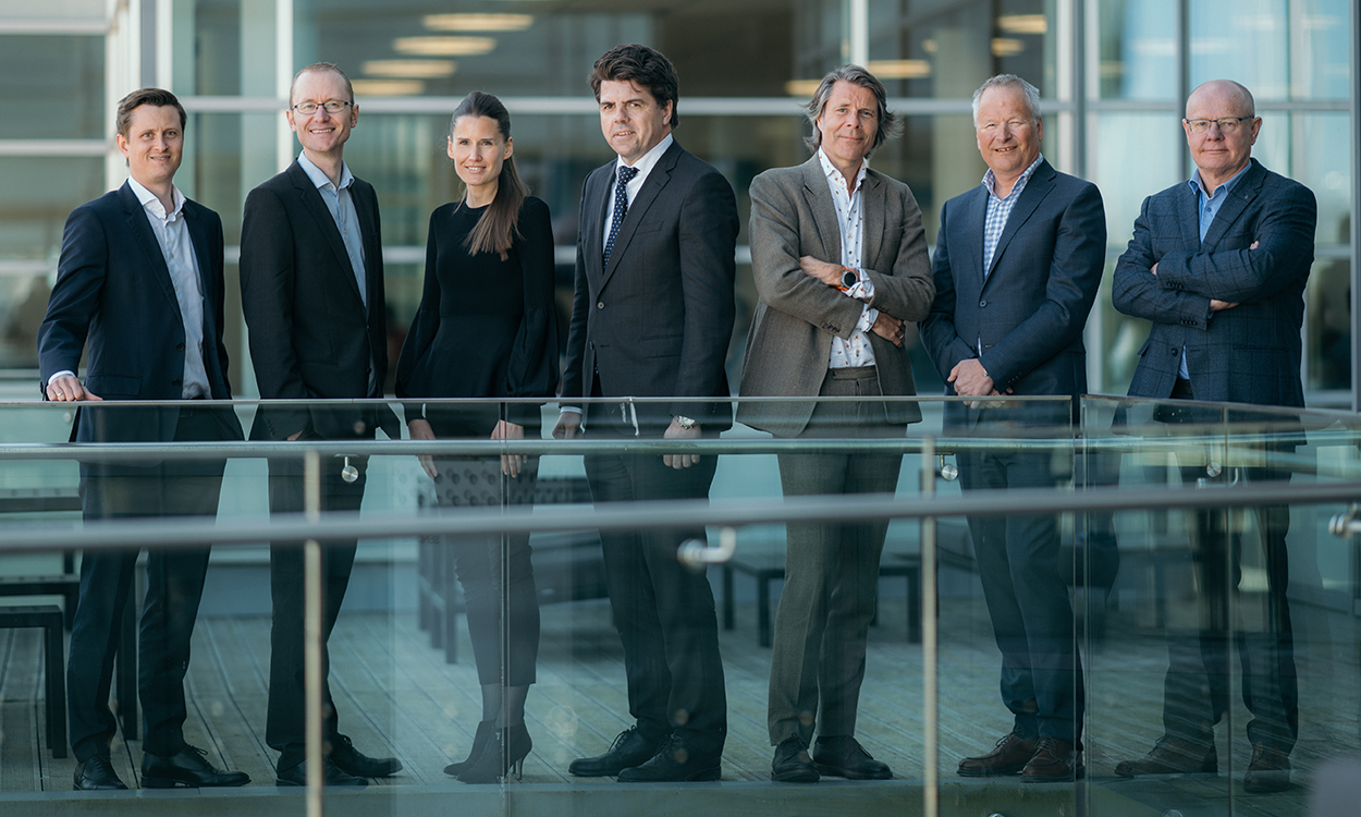 Andreas Roti, Terje Monsen, Lene Christin Våge, Anders Buvik, Svein Aage Aanes, Arne Mjelde og Johan Petter Cappelen-Dahl står på en av terrassene til DNB i Solheimsviken.