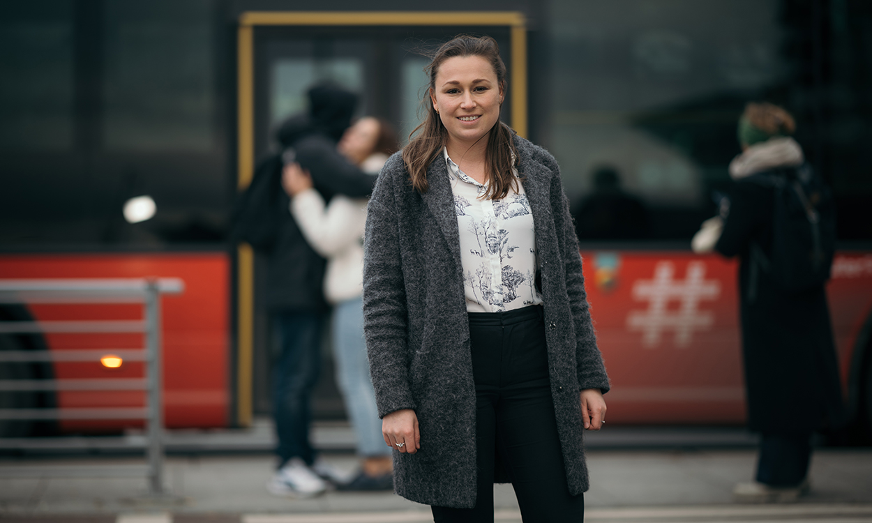 Lise Børresen står ute på gaten med mennesker og en buss i bakgrunnen.