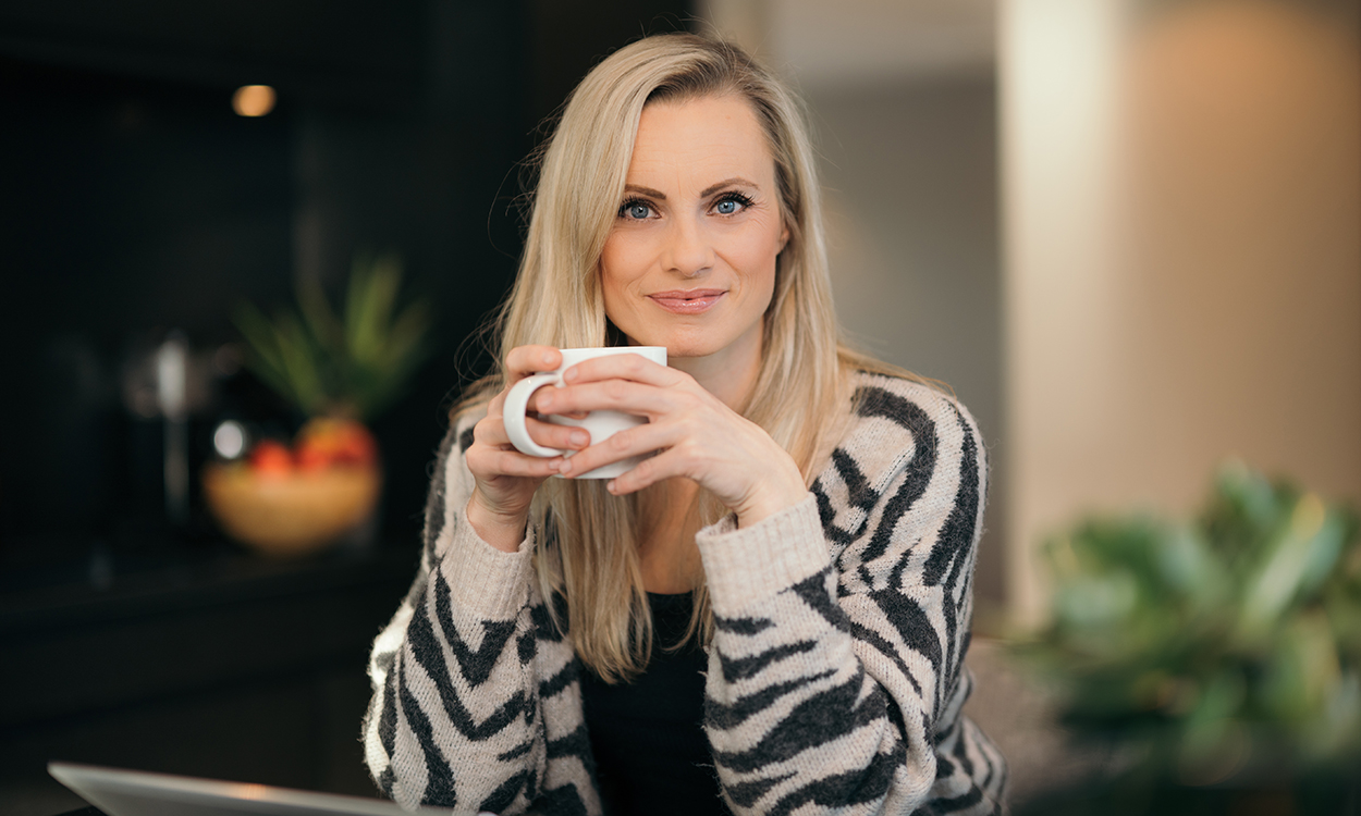 Silje Sandmæl sitter med tekopp og PC.