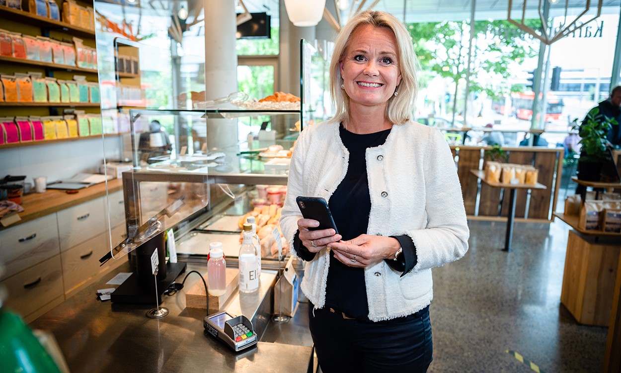 Ingjerd Blekeli Spiten smilende på Kaffebrenneriet med mobiltelefonen i hånden