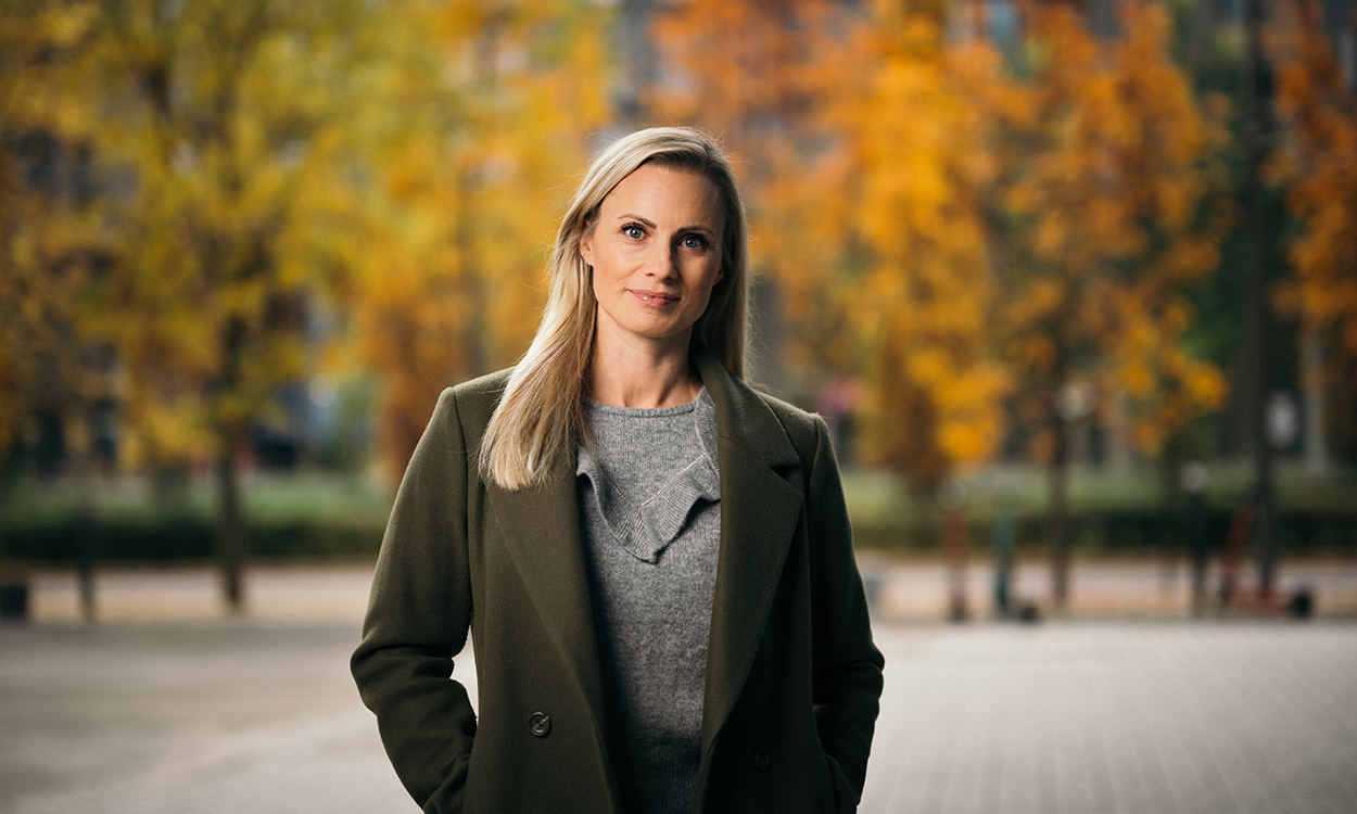 Silje Sandmæl står i gaten med trær i høstfarger.