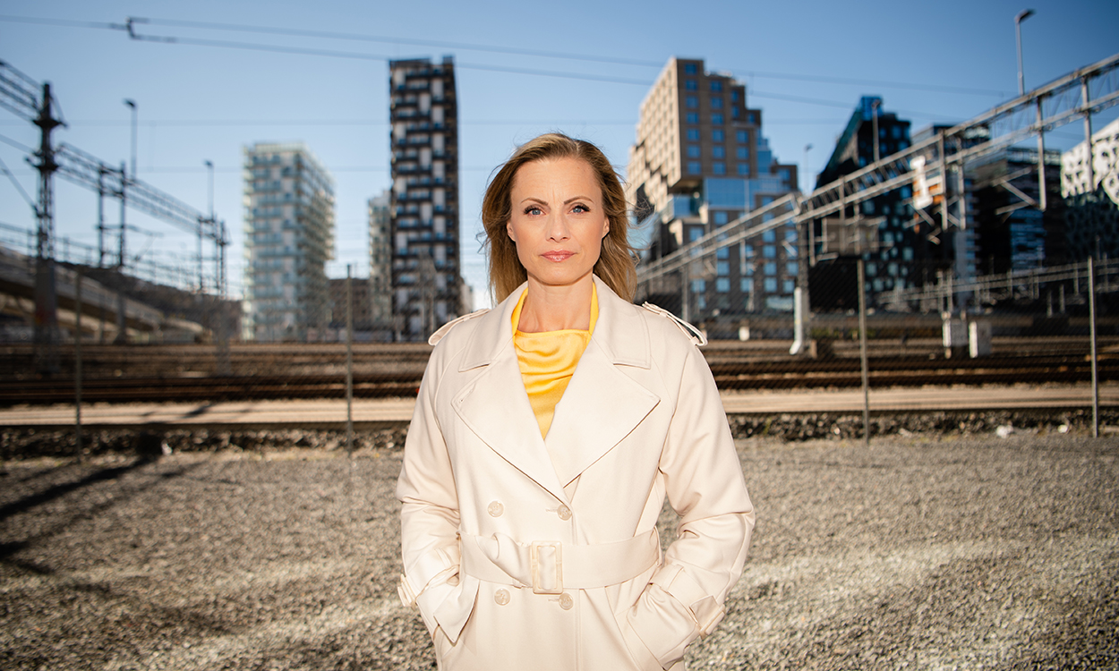 Silje Sandmæl står med barcode som bakgrunn, blant annet DNBs bygninger.