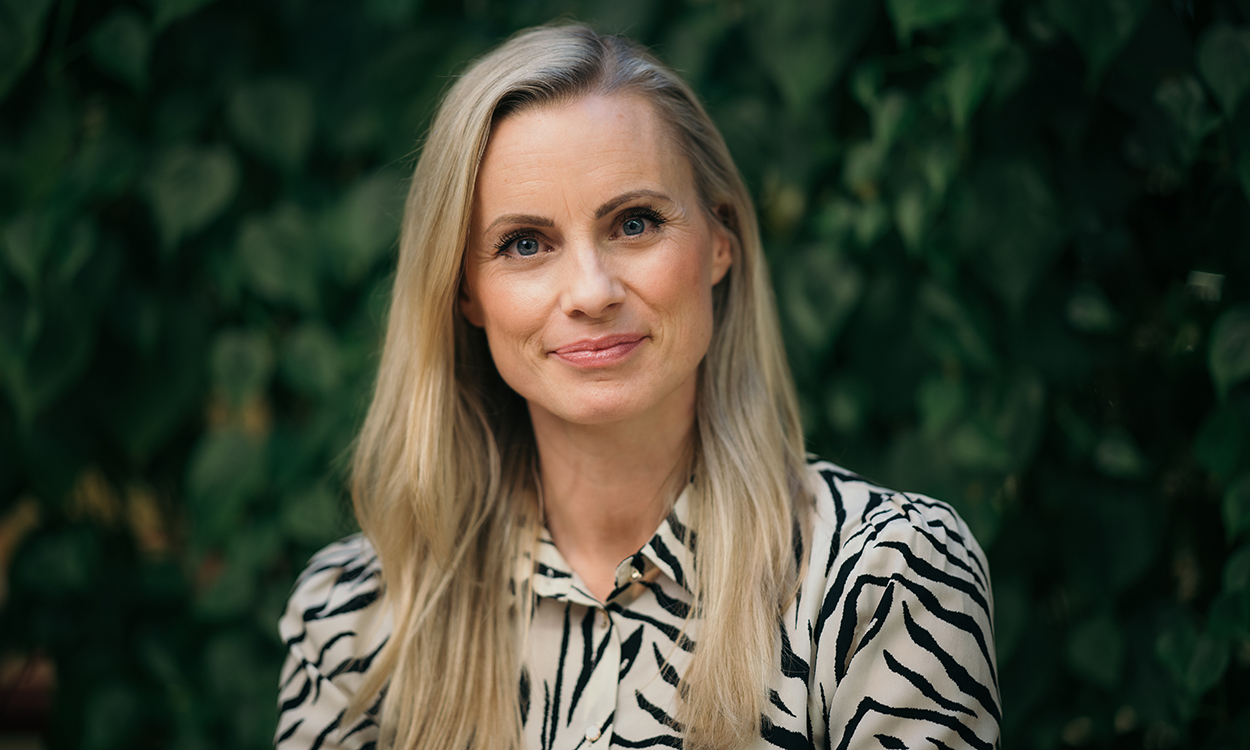 Silje Sandmæl står foran grønne planter. 