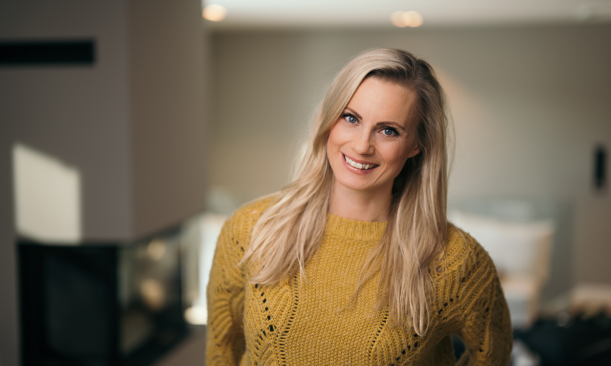 Silje Sandmæl står på stuen med gul genser. 