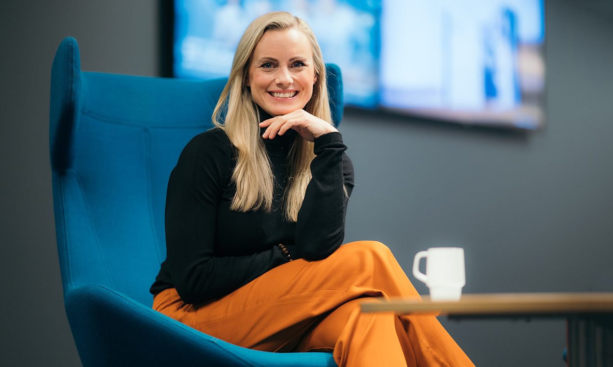 Silje Sandmæl sitter i en stol med kaffekopp på bordet.