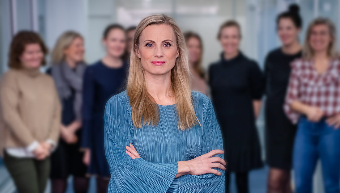 Silje Sandmæl med armene i kors foran en haug med kvinnelige kolleger