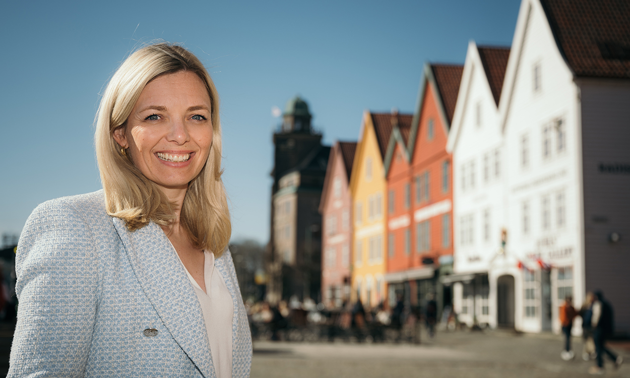 Marianne Wik Sætre står foran Bryggen i Bergen. 