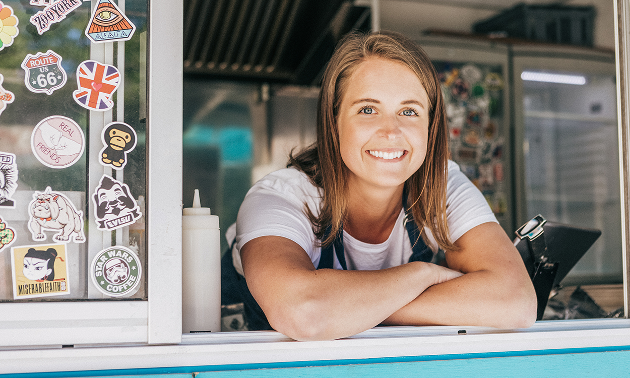 Smilende kvinne i en kiosk