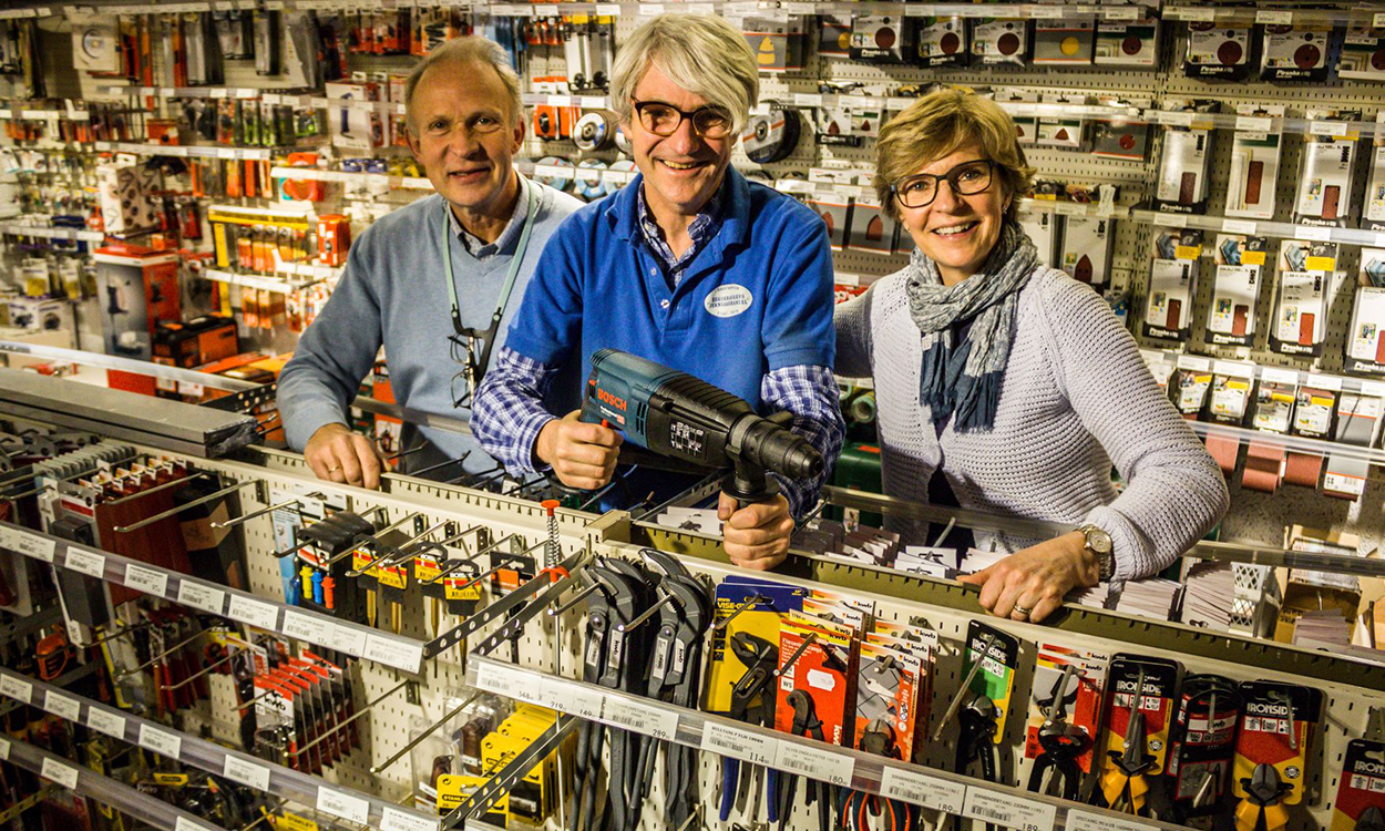 Bilde av eierne av Hegdehaugens Jernvarehandel ved en butikkhylle.