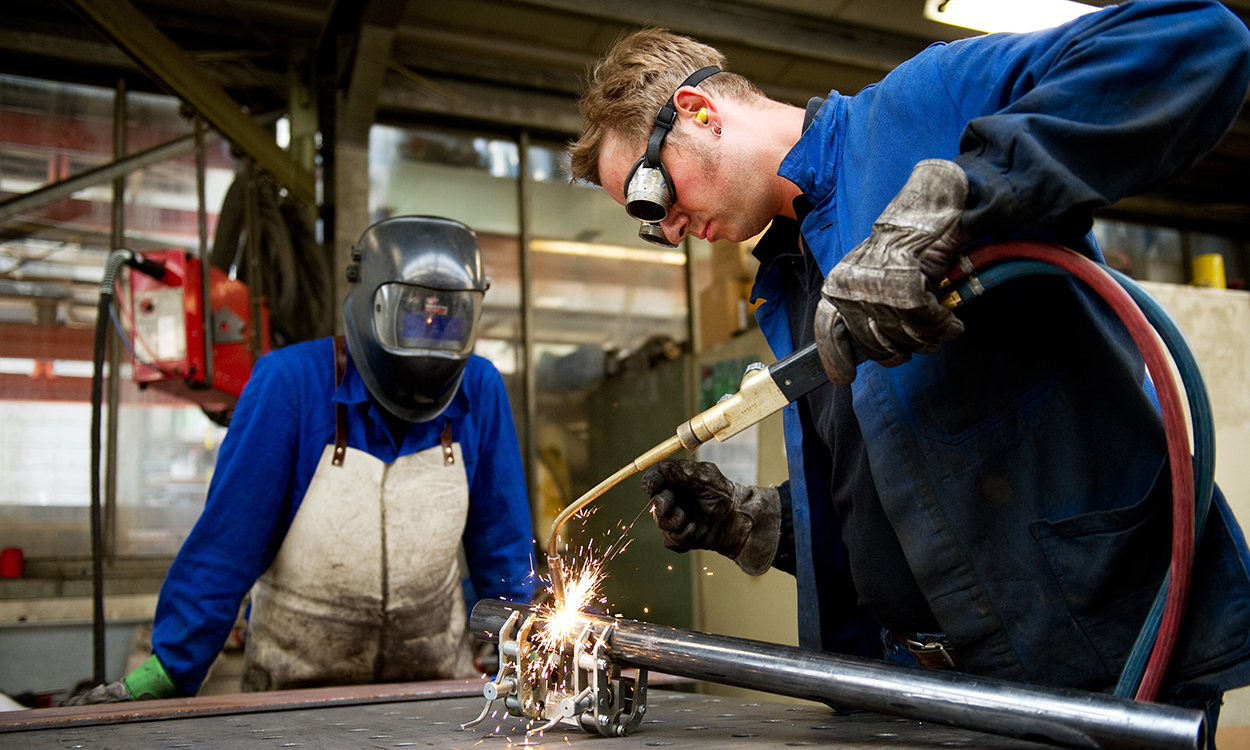 Metallarbeider sveiser. Industriarbeider. Mann på jobb. Yrkesliv. Yrkeslivet. Mann i arbeid. Mann med vernehjelm ser på. Kollega. Kollegaer.A metalworker welding.Foto: Jan Haas / NTBNB! MODELLKLARERT