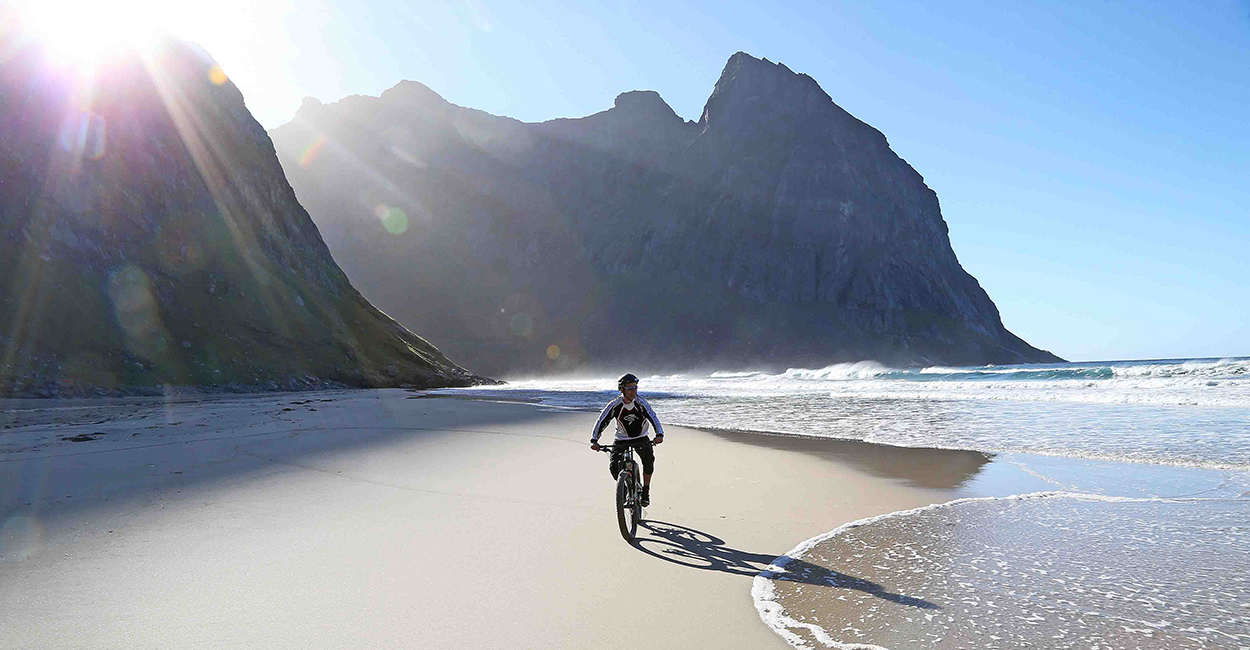 en mann sykler i Lofoten.   