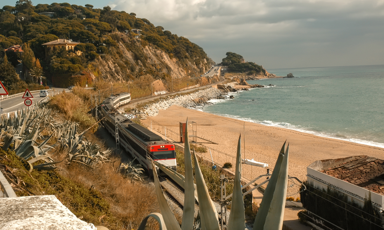 bilde av tog som kjører langs Middelhavet i Spania
