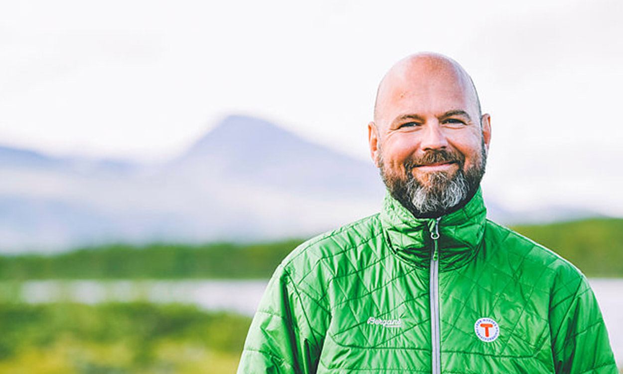 Portrett av Dag Terje Klarp Slovang, smilende på fjellet iført grønn DNT-jakke
